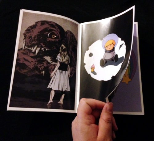 Photo of hand turning a page of the art booklet