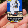 Photo of hand holding Please Stop Clubbing, Baby Seals pin
